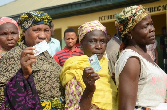 Women show their voter ID cards as the queue at the polling station during the Nigerian general elections in February 2019.