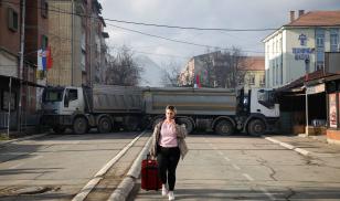 A woman walks near a roadblock, in the northern part part of the ethnically-divided town of Mitrovica, Kosovo